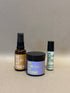 Amber glass spray bottle labeled Be Silky My Friend, purple jar with No Rub My Friend label, and small cream tube with Be.